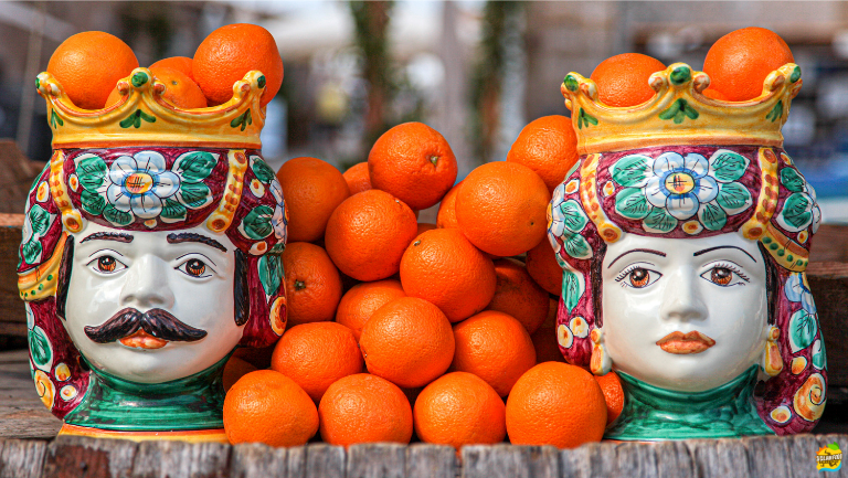 A pair of traditional Sicilian Testa di Moro ceramic vases on a sunlit balcony in Palermo, Sicily